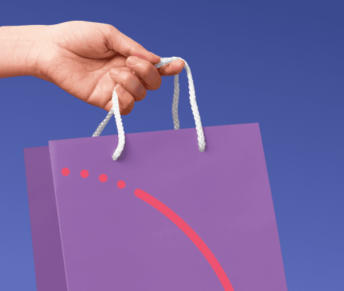 Hand holding a purple shopping bag with red curved design