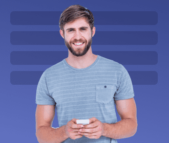 Smiling man holding a smartphone against a blue background